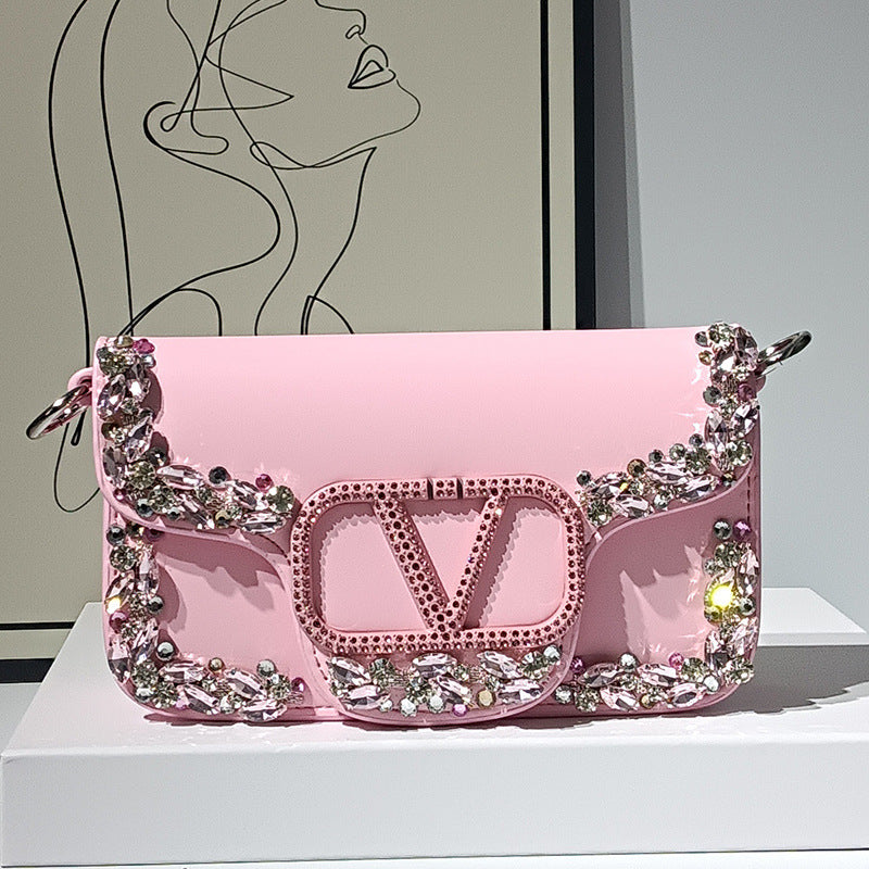 Pink handbag with decorative elements on a white surface